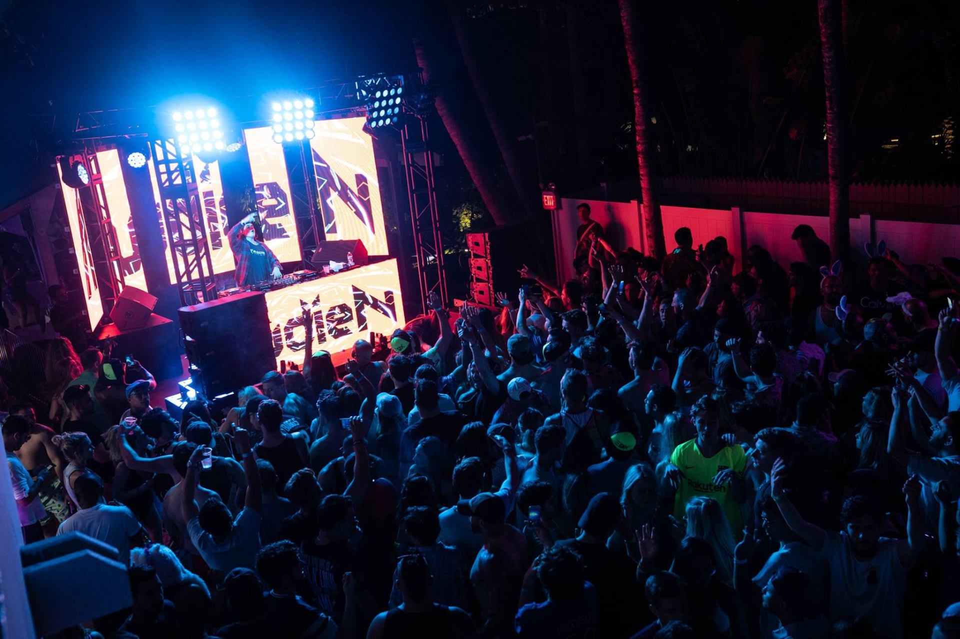 Headline DJ set under stage lights with packed pool-deck crowd